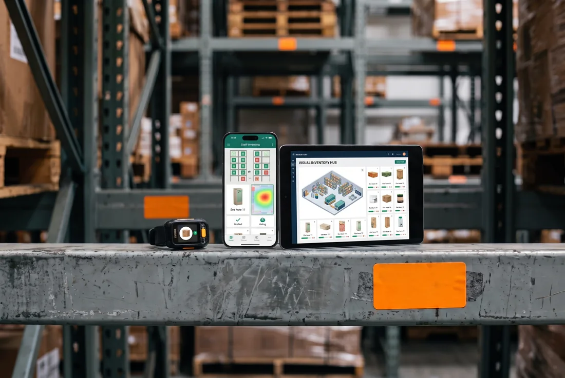 A smartwatch, smartphone, and tablet resting on the same warehouse racking beam, showing Spatialis OS running a live inventory heatmap, staff task screens, and a 3D visual inventory hub.